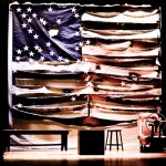 American flag displayed on rustic wooden shelving with vintage books and small decorative stool